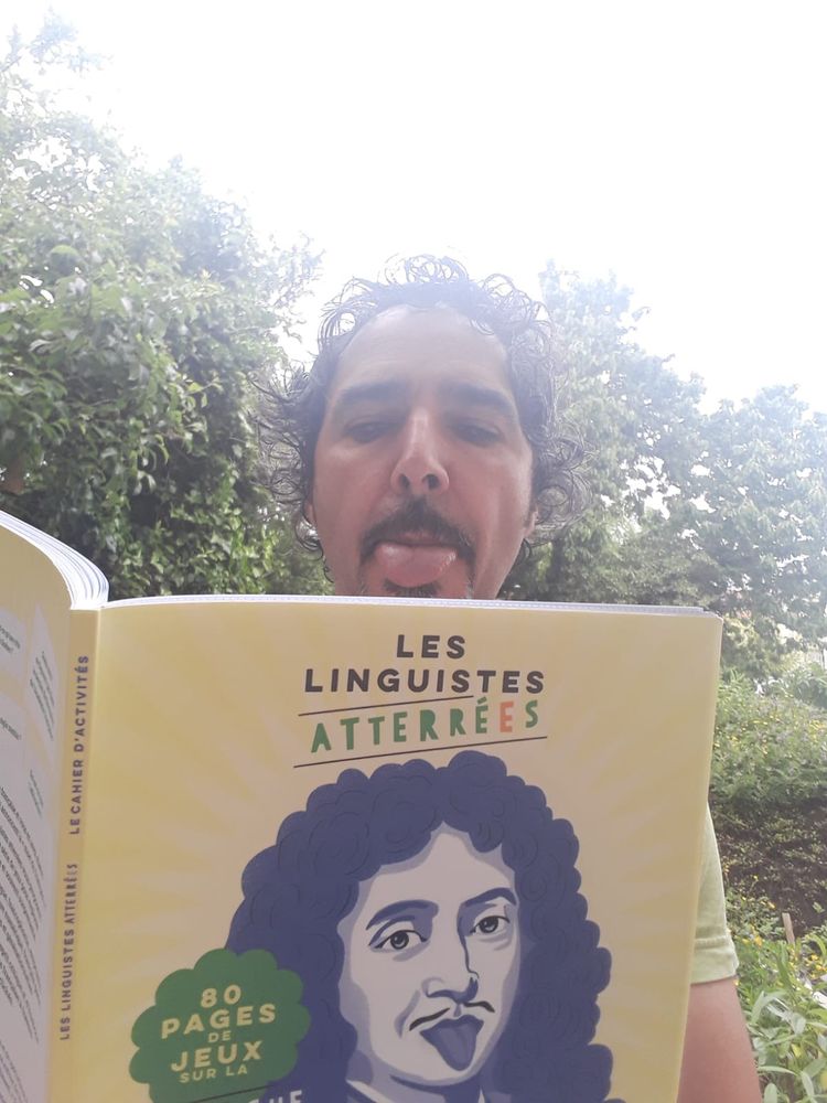 Photo de Christophe Benzitoun dans un jardin tenant le cahier