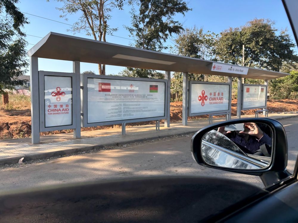 Bus stop with sign advertising aid from China