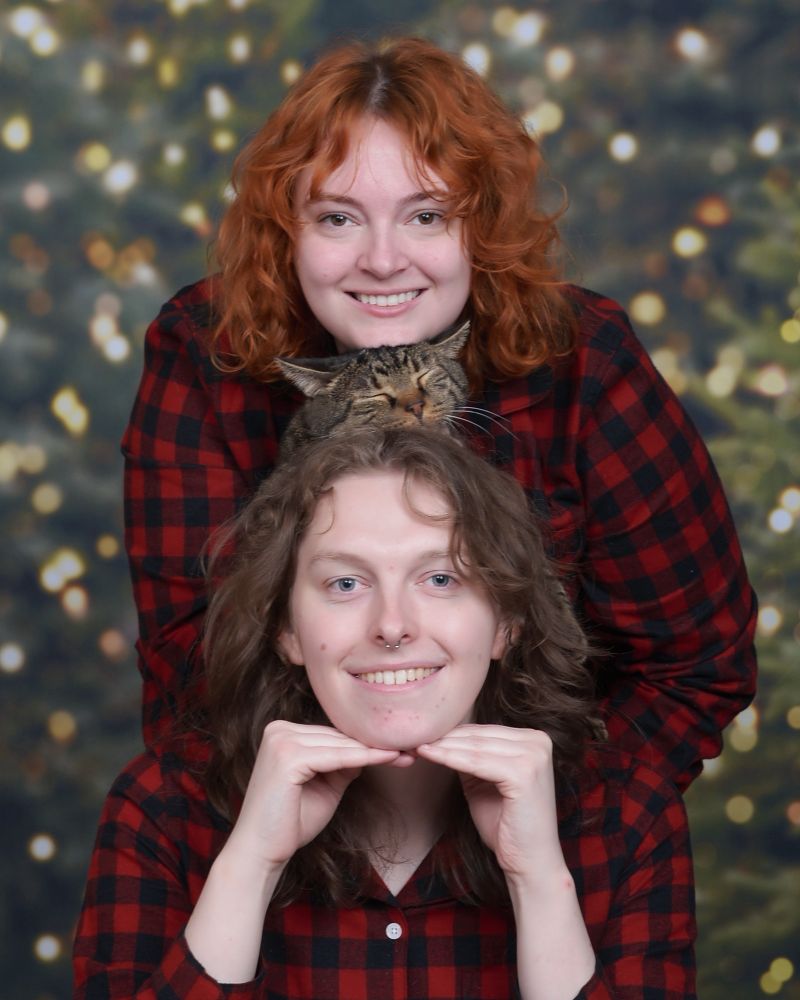 a silly christmas card photo with dani, izzy, and our cat seamus wearing red striped pajamas 
