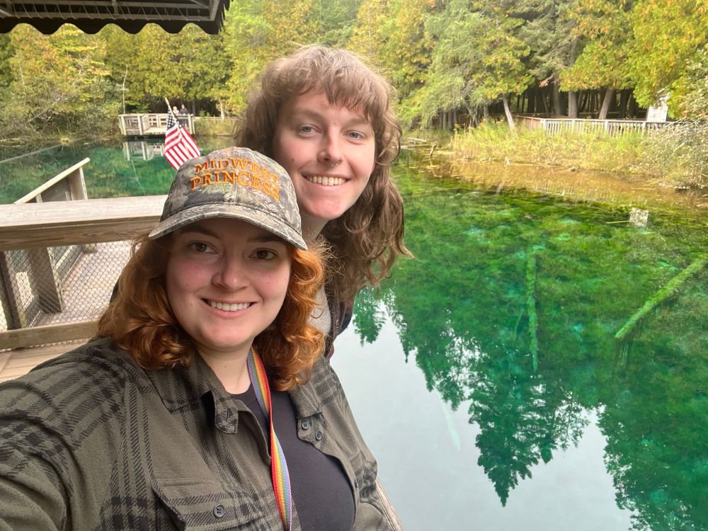 dani and izzy on a boat overlooking a remarkably clear water source