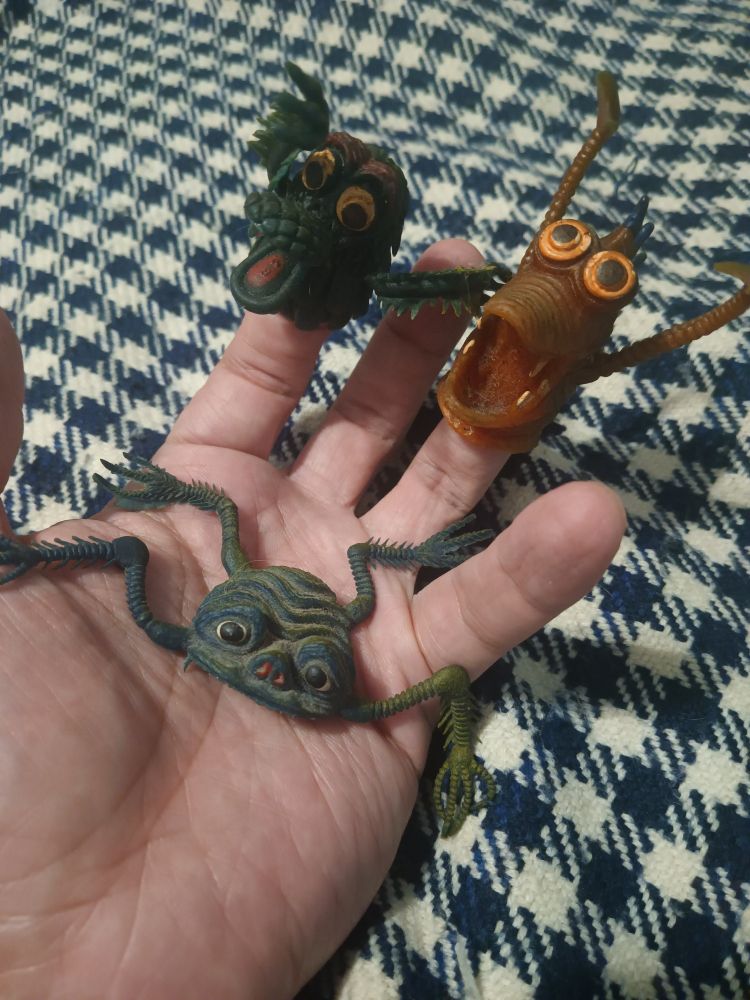 a hand with some finger puppets and a jiggler toy