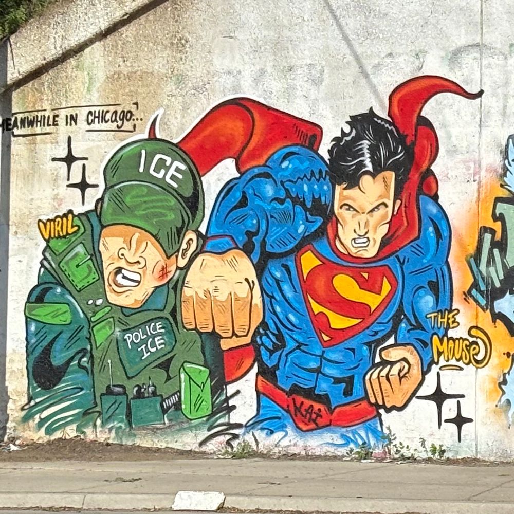 Street art mural of Superman punching an ICE agent,