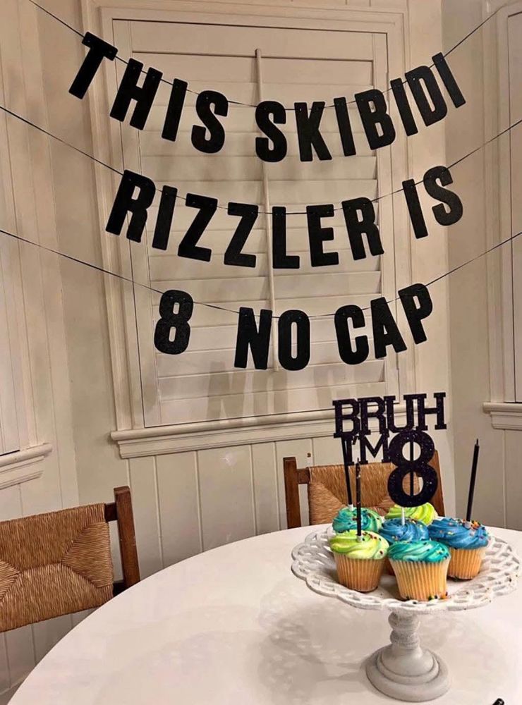 Party decoration saying THIS SKIBIDI RIZZLER IS 8 NO CAP with a tray of cupcakes saying BRUH I’M 8