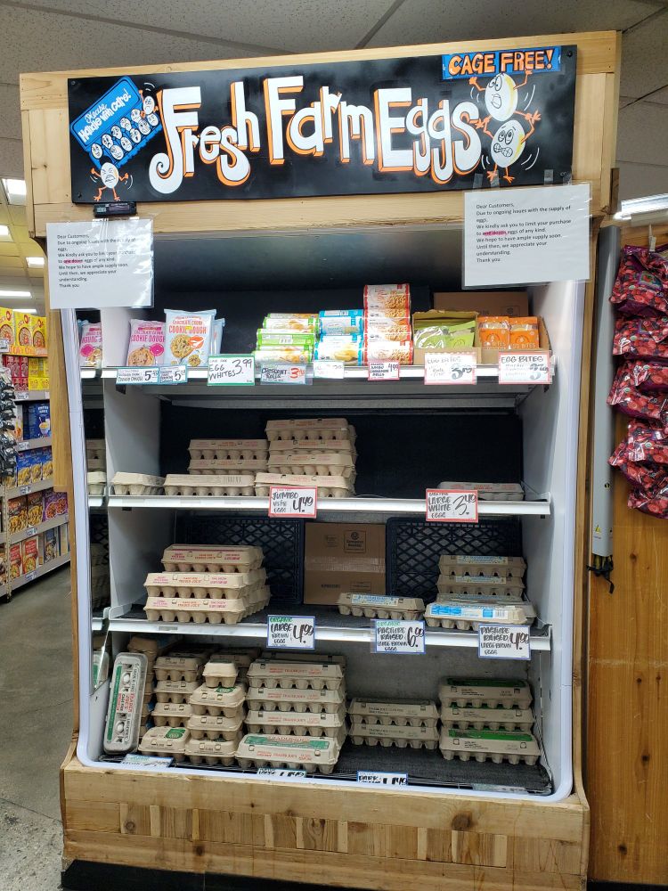A partially full display of eggs at Trader Joe's, with prices starting at $3.49 a dozen.