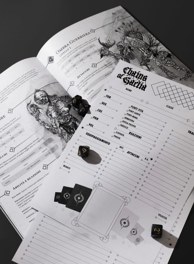 A photograph of a spread of the Chains of Gaelia Quickstart Guide, depicting a Lesser Shadow and a Warrior Shadow. On top of it there are two blank character sheets, as well as some black dice with gold inlays.