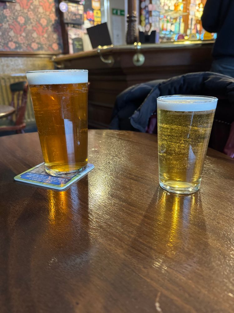 A pint and a half pint on a pub table 