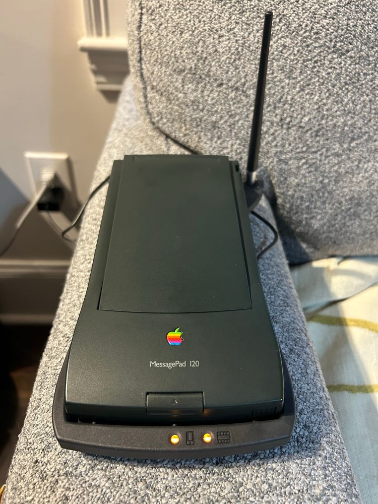 my newton messagepad 120 in its charging dock!! a spare stylus sticks up from the charging stations holder like an antenna