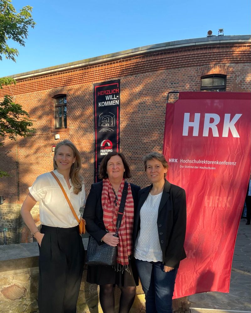 v. l. n. r.: Alexandra Kühnen, Dr. Sybille Jung & Michaela Frohberg neben einer roten HRK Fahne