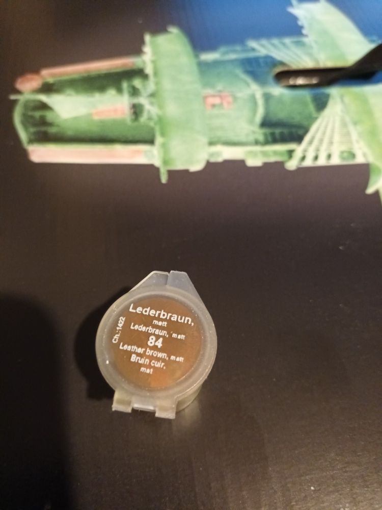 A small pot of brown paint.