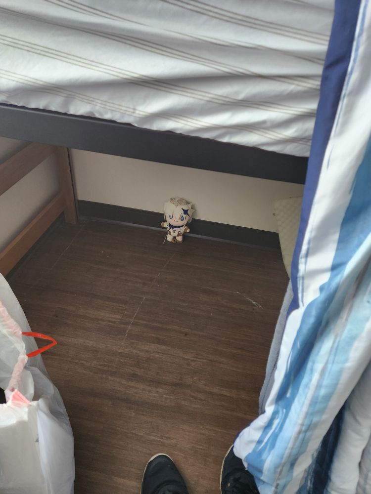 A paimon ( genshin impact ) plush standing under my loft bed all alone