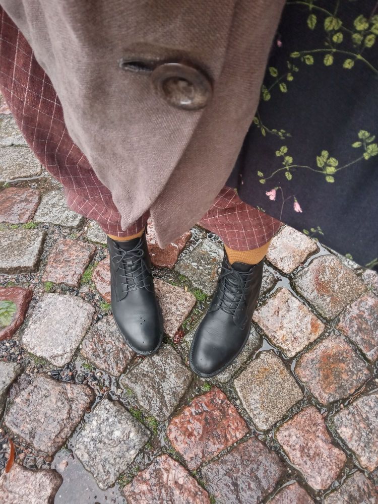 Kuvassa söpöt mustat nauhakengät jalassa, keltaiset sukat ja kaikenmoista pellavaa. Sataa.