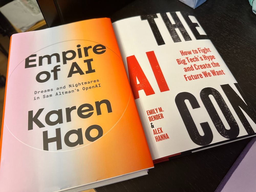 Two books side by side - Empire of AI: Dreams and Nightmares in Sam Altman's OpenAI by Karen Hao, and The AI Con: How to Fight Big Tech's Hype and Create the Future We Want by Emily M. Bender & Alex Hanna.