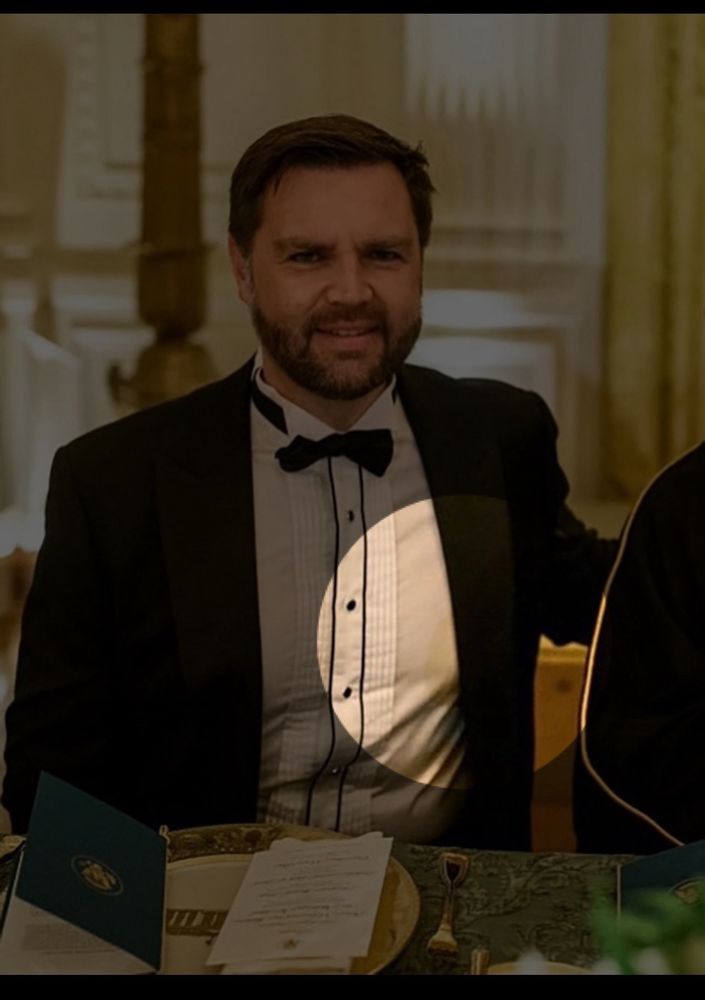 jd vance in an ill-fitting tuxedo shirt with a strange stain on his lower-left side below his nipple