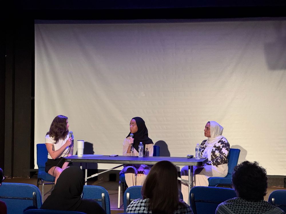 Jess Scarane, Madinah Wilson-Anton and Zainab Sultan seated at a table with microphones, discussing Sultan’s short documentary film “Stand Up For Madinah”