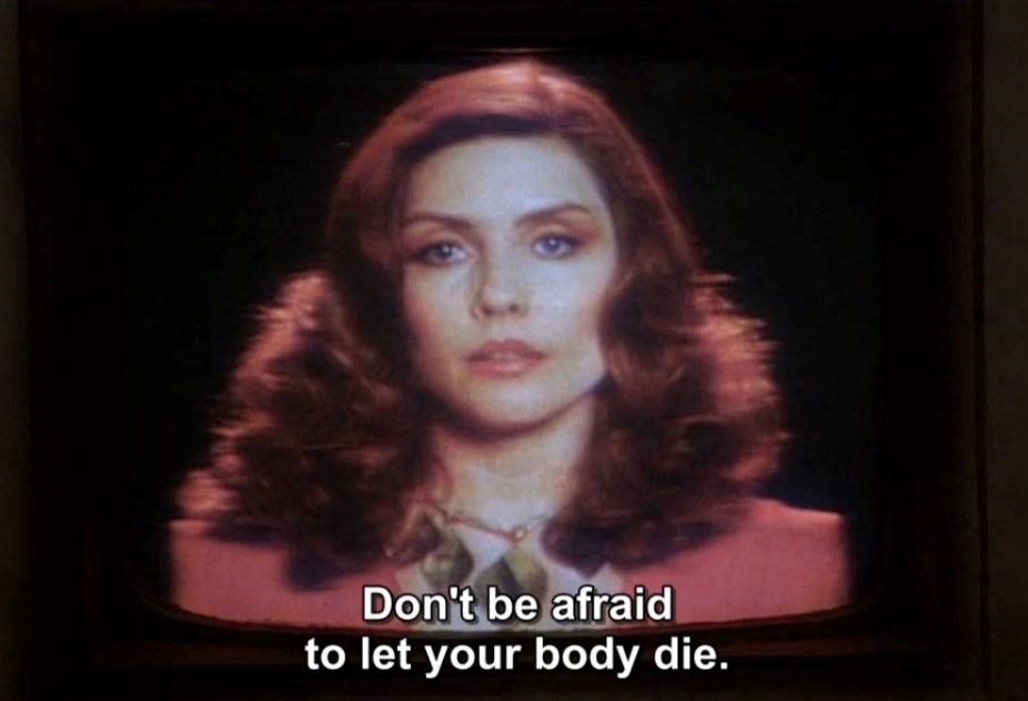 A screen capture from the movie Videodrome with Debbie Harry on a television screen saying "Don't be afraid to let your body die."