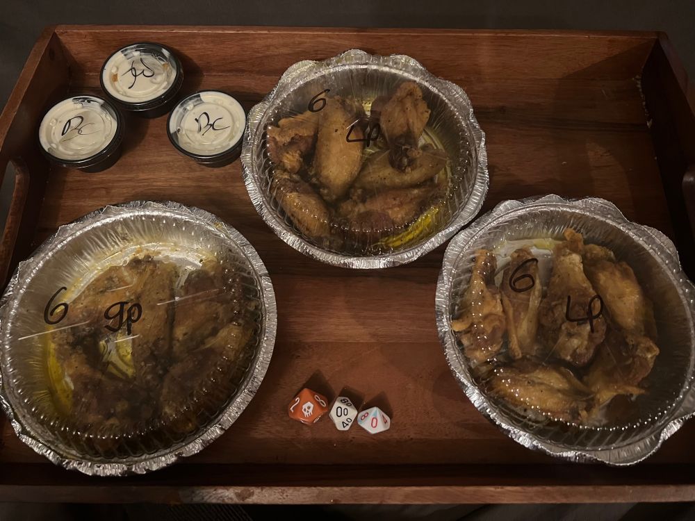 18 buffalo wings on a tray with some dice to act as counters 