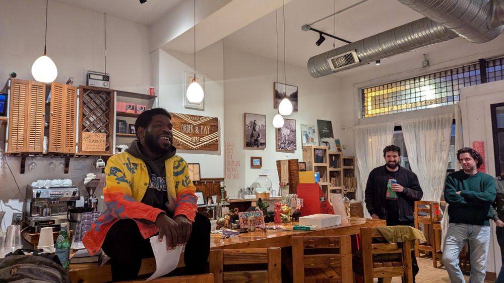 Hanif Abdurraqib sits on a bar at Two Dollar Radio HQ 