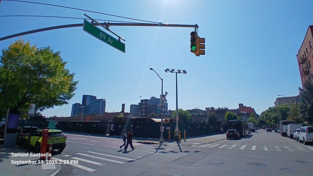 The old 165 Street bus terminal is closed. Green wood dividers now surround the perimeter as the teardown of the old terminal is underway in the background.