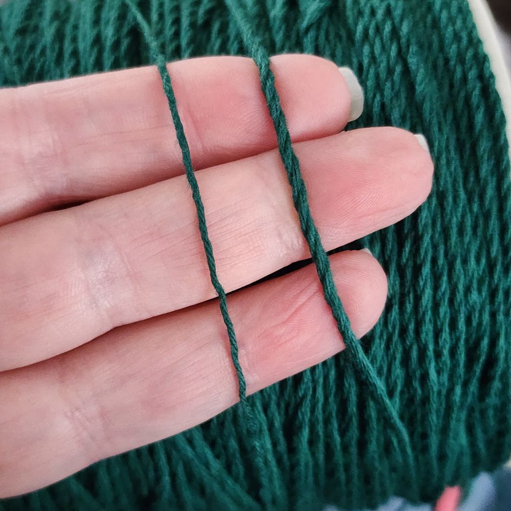 The original cotton yarn is on the left, and on the right is the result of plying three strands of it together.