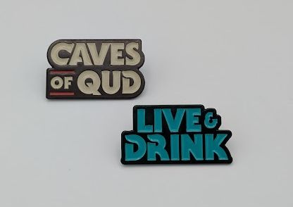 Photos of two pins: one saying Live & Drink and the other Caves of Qud
