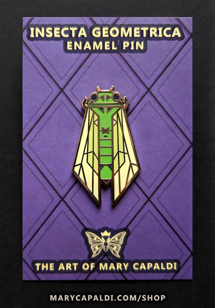 Photo of an enamel pin of a green cicada done in a symmetrical geometric design with straight lines forming every shape of its body. It's shown on a purple backing card that reads "Insecta Geometrica Enamel Pin" at the top and "The Art of Mary Capaldi" with a crowned moth logo at the bottom.