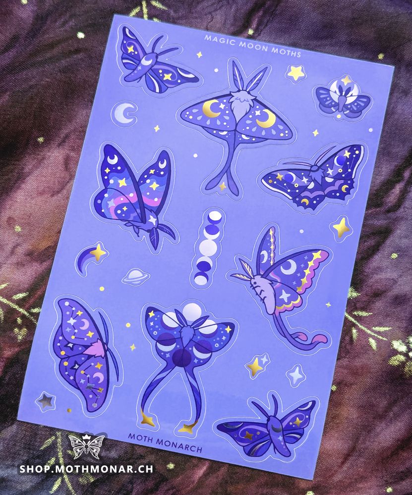 Photo of a lavender sticker sheet with whimsical celestial-themed moths and related accent stickers. Nine moths have moons, stars, and small constellations on their wings with purple, blue, and pink palettes. Their shapes are inspired by real species like the luna moth, comet moth, cecropia moth, sphinx moth, etc. Accent stickers include four-pointed stars, five-pointed stars, a moon, a planet with a ring, and a four-pointed comet as well as a line of moon phases vertically in the middle of the sheet. Some of the stars, moons, and markings have metallic details catching the light here. The top of the sheet reads "Magic Moon Moths" and the bottom has the artist's name, "Moth Monarch".