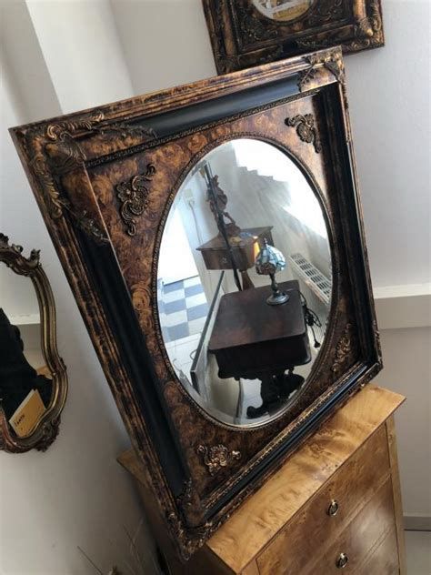Historic mirror with beveled edges in decorative wooden frame. Beveled edges were particularly popular around 1900 and are a quality feature of antique mirrors.