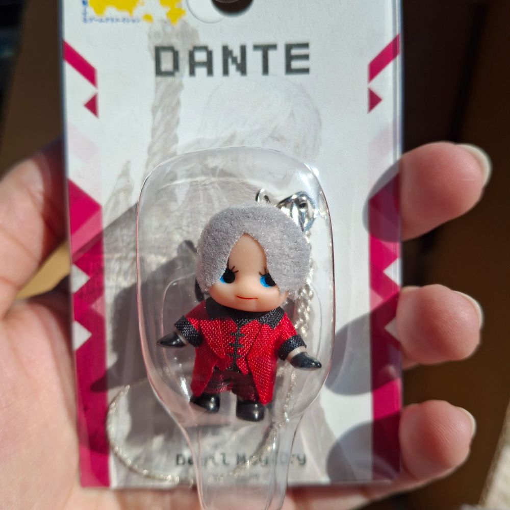 A small kewpie doll of Dante from DMC 1. He looks like a small baby with red clothes. 