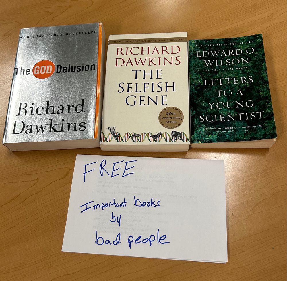 Three books: The God Delusion, The Selfish Gene, and Letters to A Young Scientist. Accompanying sign says Free. Important book by bad people 