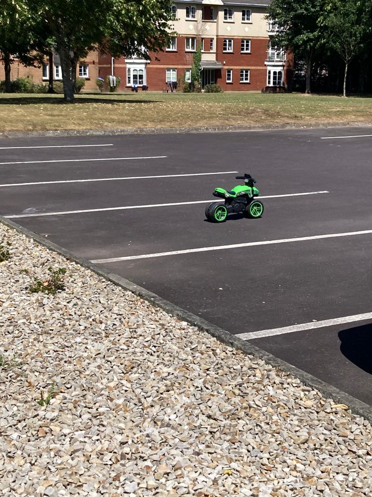 Closer on the bright green toy motorbike