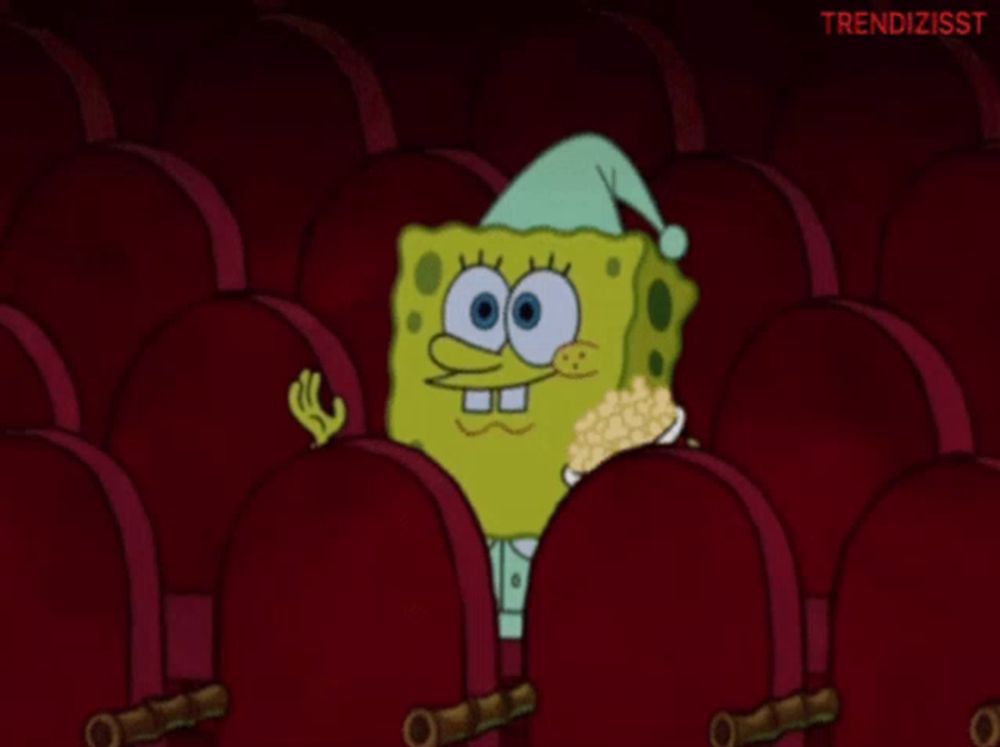 a cartoon of spongebob sitting in a theater with a bowl of popcorn