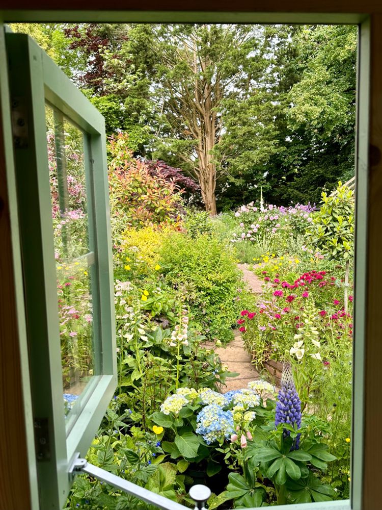 English country garden view from a window in June. 