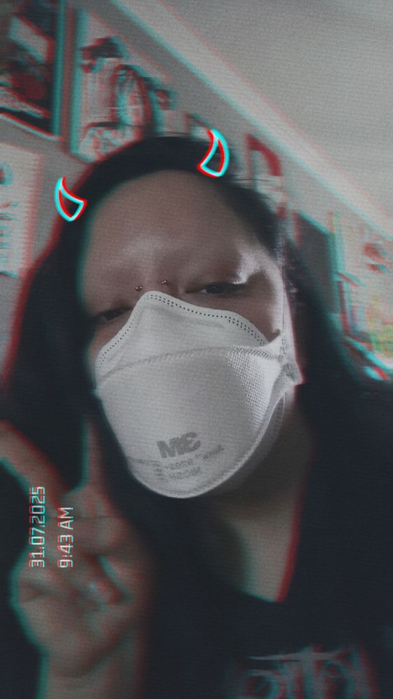 ness fatale from the top of his chest, up, with a peace sign up from his right hand. they're wearing a 3m aura facemask and have a snapchat filter with horns on top of his head