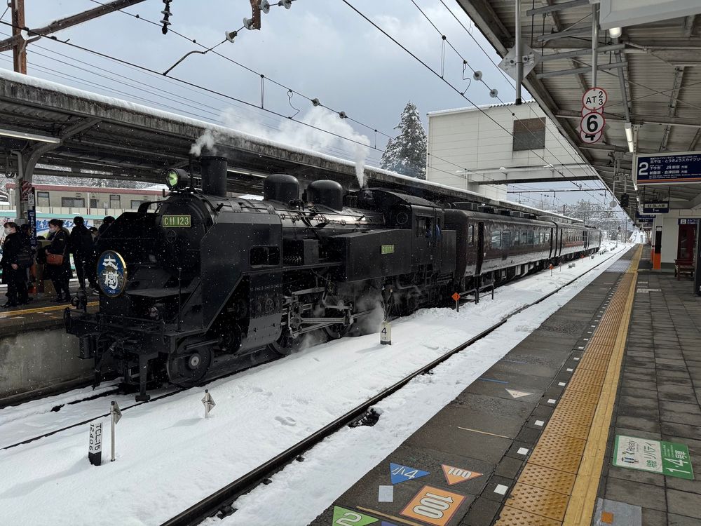 鬼怒川温泉駅ホームに止まるSL大樹。煙突から煙が出ている。