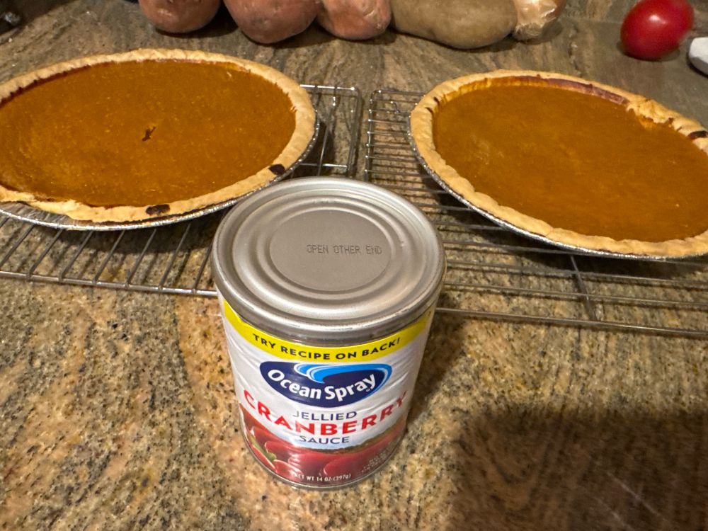 Two pumpkin pies and a can of jellied cranberry sauce. 