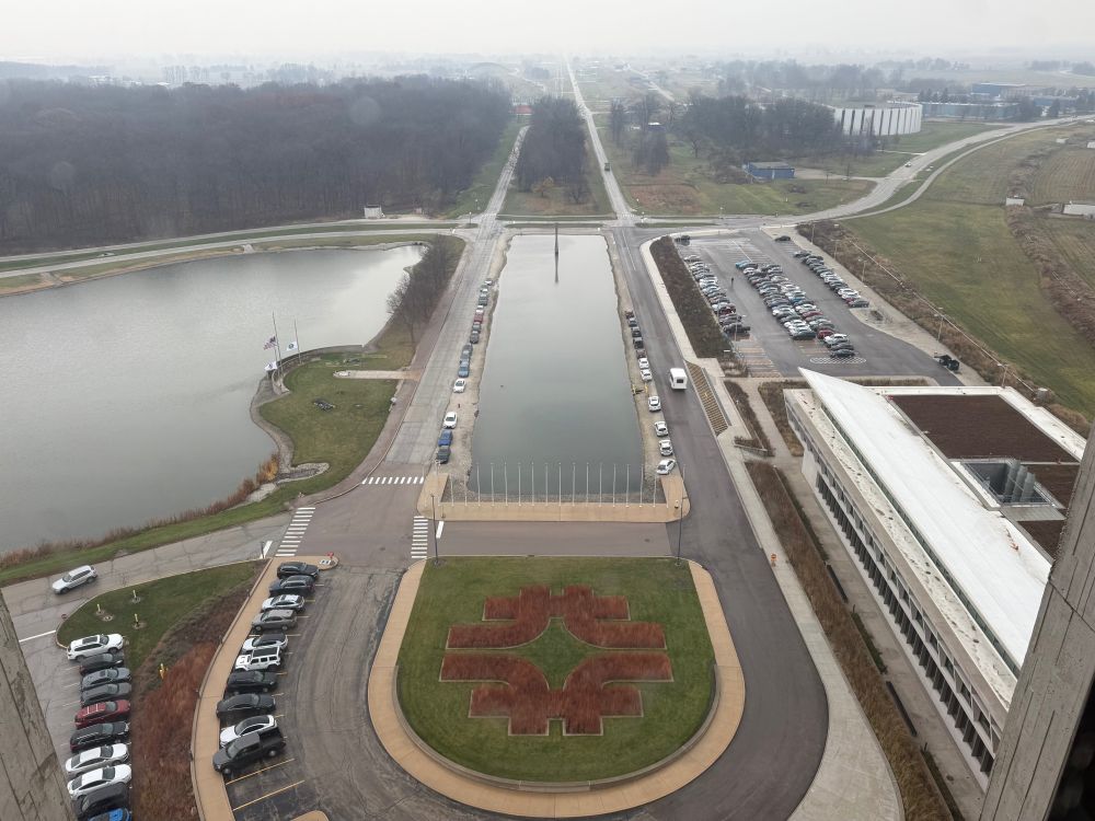 The main parkway at Fermilab with a topiary designed in the shape of the Fermilab logo