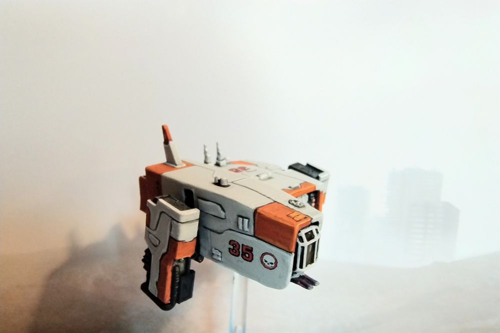1:300 scale model of a sci-fi dropship painted in white with orange accents