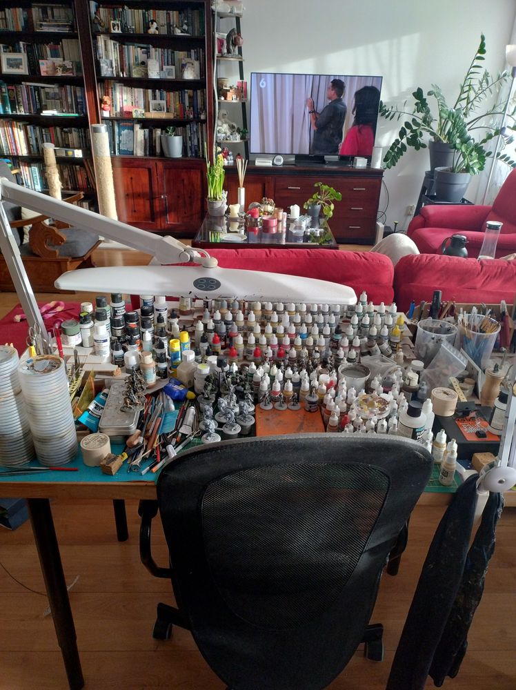 Messy paint desk in the back if the living room facing the television 