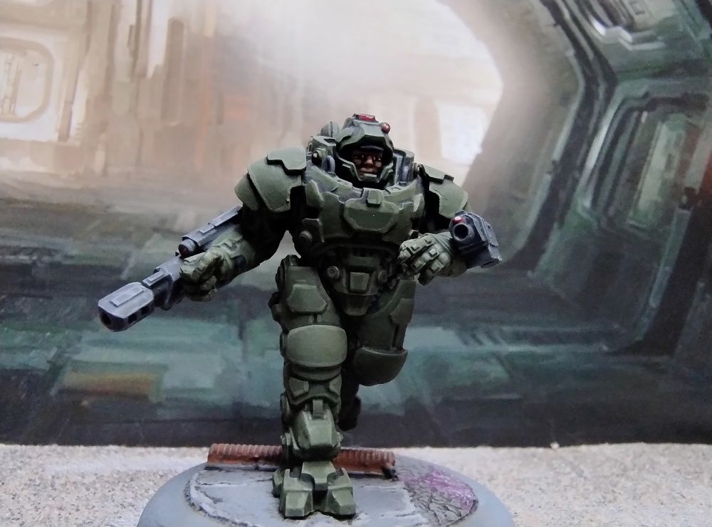 28mm Science fiction figure in heavy armour running towards the camera. Helmet visor open.