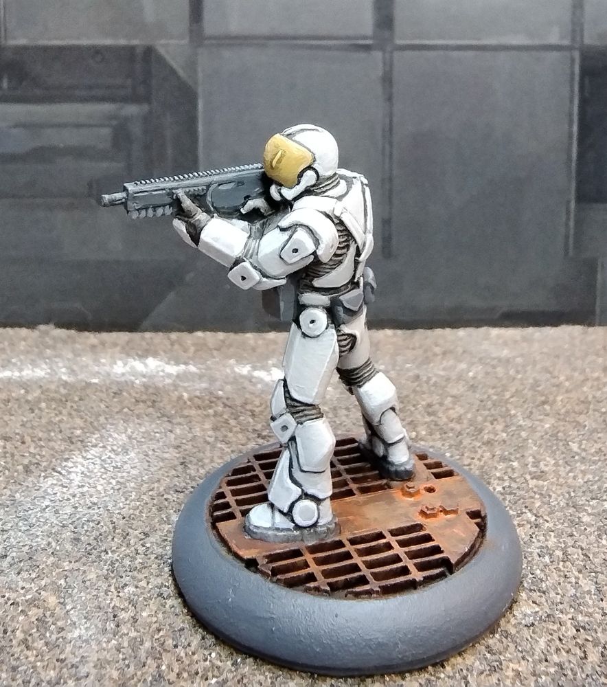 Painted 28mm science fiction figure aiming a weapon facing to the left