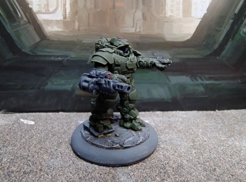 28mm Science fiction figure in heavy armour pointing at a target and raising a heavy grenade launcher. 