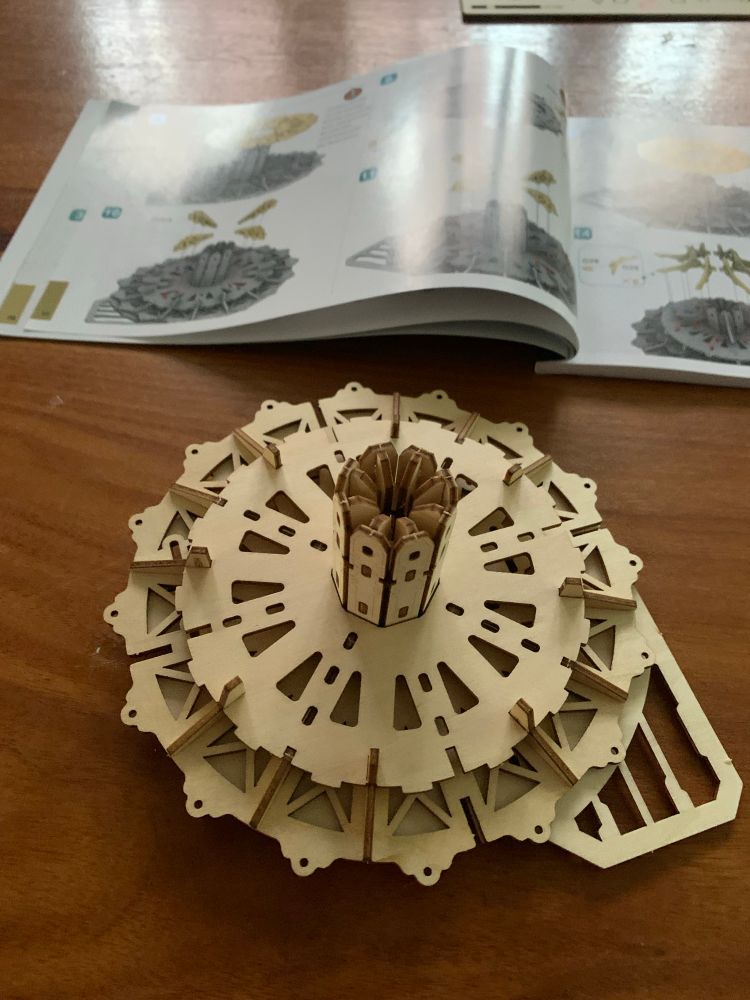 laser cut wooden model of a steampunk city assembly. very intricate. 