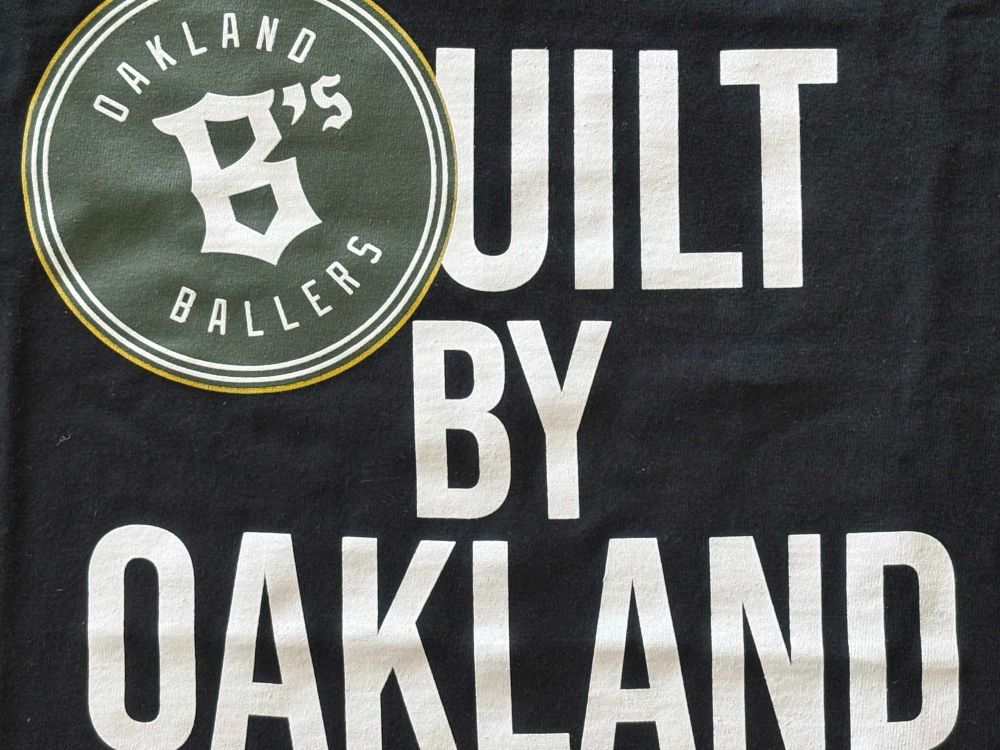 Pictured here: an Oakland Ballers t-shirt bearing the words, "Built by Oakland," with a "B" consisting of the Ballers logo. This t-shirt was obtained by its wearer becoming a fan investor for $510. The Oakland arts works the same way: Co-creators make an investment with each play, another pass of the communal brush. What a lovely culture portrait.