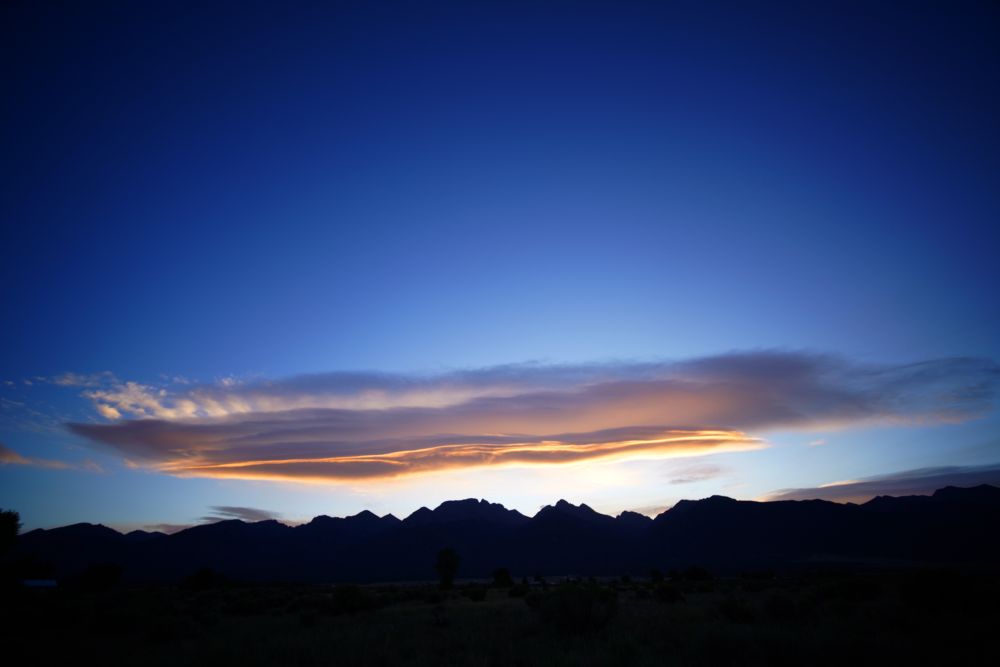 Now the sky is lighter blue and the stars have disappeared. The long lenticular cloud is illuminated orange by sunrise. The house lights have also disappeared in this frame. It is dawn.