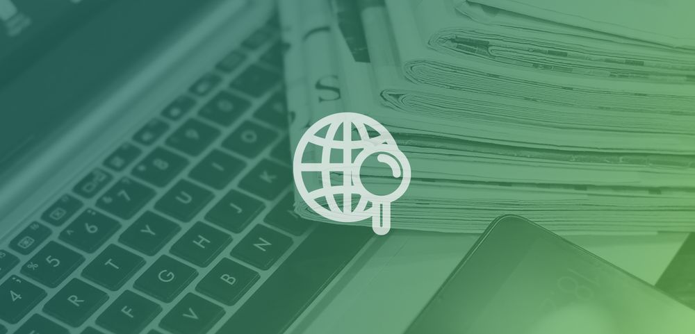 Image of laptop under a stack of newspapers. A green and blue overlay covers the image, with a central white icon of a globe and magnifying glass.
