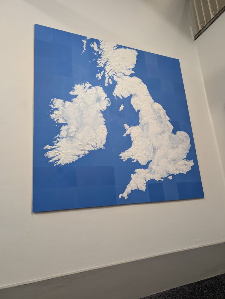 A large 3d printed wall map of the British and Irish Isles mounted to a wall. 