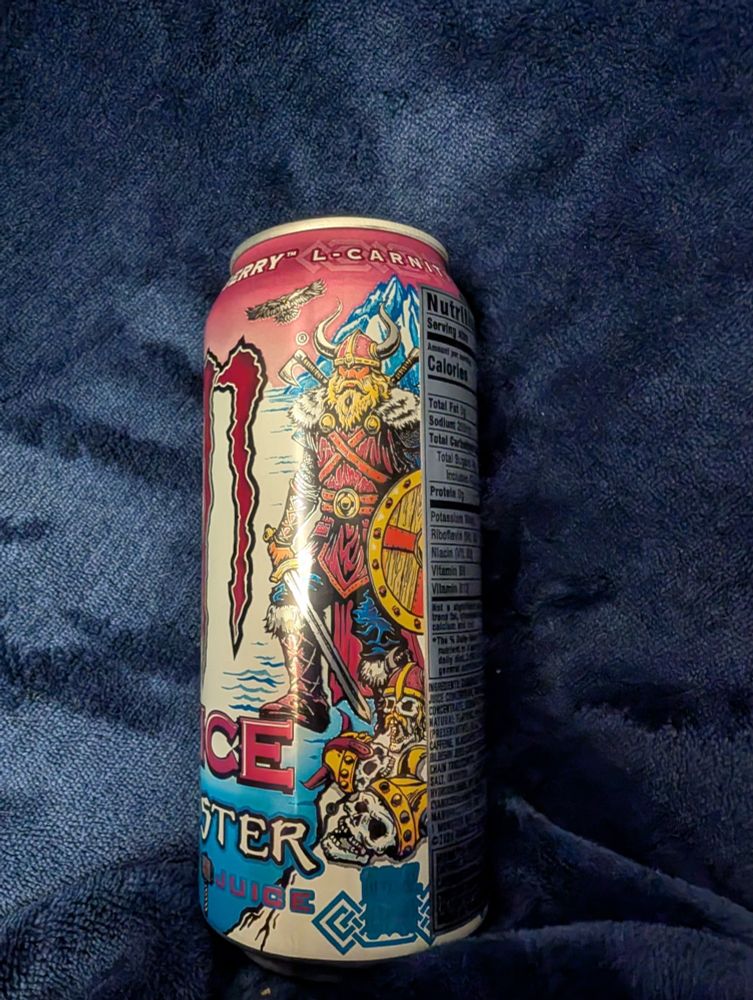 Monster can, viking berry, it's a sunset over a fjord with a blonde bearded viking dude with a sword and shield standing next to a bunch of skulls.