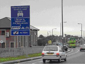 High occupancy vehicle lane sign with cars and buses around it