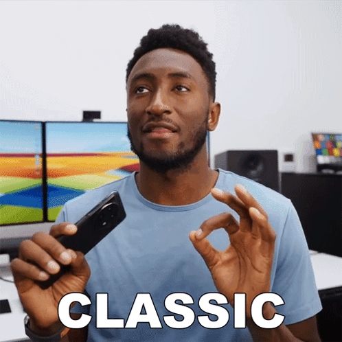 a man in a blue shirt is holding a cell phone and the word classic is on the screen