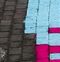Crop from the quoted photo where the trans flag and pride flag merge, highlighting how the trans flag takes up one row of bricks extra compared to the pride flag.

They've done the pride flag with 6 stripes of 4 bricks, making 24 and the trans flag as 5 stripes of 5 bricks, making 25. If they had the space for one extra brick per stripe in each design they would have matched perfectly at 30 bricks total. It looks like it would have been possible, however the final stripe of each design would be passing under the benches